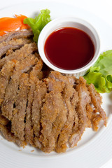 Battered pork with sauce on a plate
