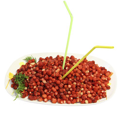 Ягоды земляники на большом блюде с трубочками для коктейля