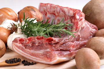 rohes Schweinefleisch mit Rosmarin, Kartoffeln und Zwiebeln