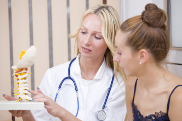 doctor showing patient spine bones