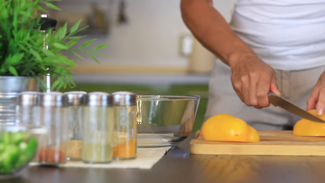 Female hands slicing yellow pepper, dolly shot