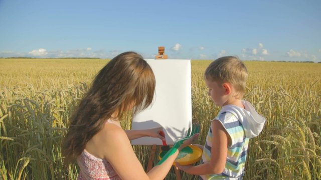 Woman showing boy the original version of painting by hand