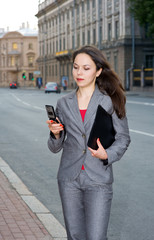 Business woman with mobile phone and folder