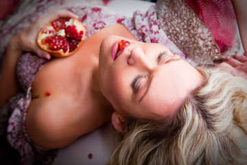 Obraz na płótnie Canvas Lying woman with pomegranate