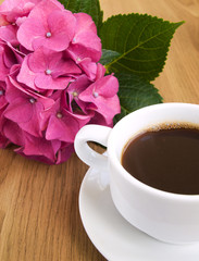 Obraz na płótnie Canvas Cup of coffee and pink hydrangea
