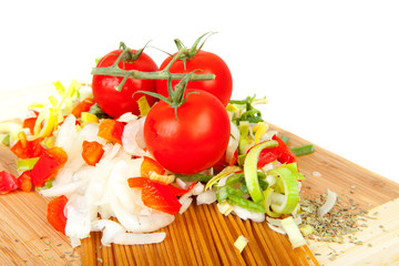 Ingredients for spaghetti on wooden cutting board
