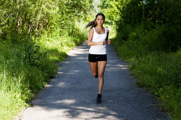 young woman jogging in the park in summer