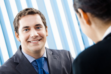 Two businesspeople, or businessman and client, at office