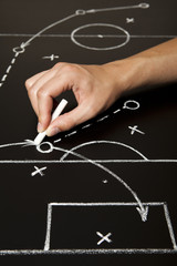 Obraz premium Coach hand drawing a football soccer game strategy