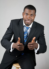 Smiling successful businessman with thumbs up