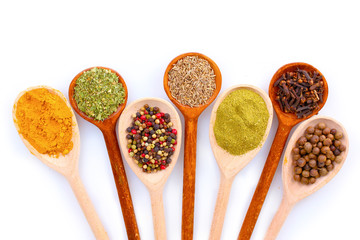 spices in the spoons isolated on white