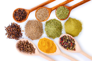 spices in the spoons isolated on white