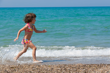 Child and sea. Running kid on the beach
