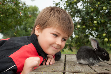 A boy with a rabbit in the garden at the cottage