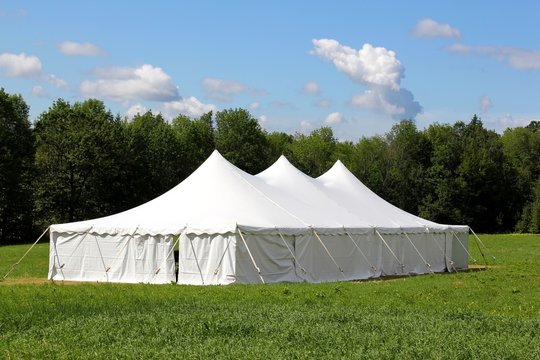 a white wedding or entertainment tent in a green field
