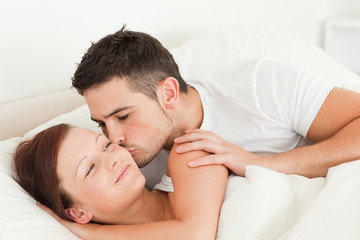Obraz na płótnie Canvas Man kissing his wife on the cheek