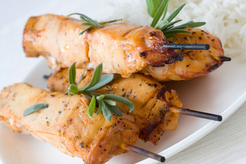 juicy chicken kebab on white plate with rice