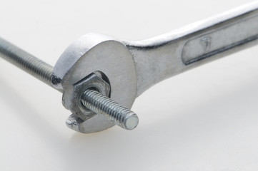 Llave tornillo, tuerca en fondo blanco