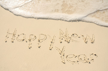 Happy New Year Written in Sand on Beach