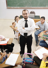 Teacher with children in classroom, boys and girls in school