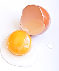 Broken brown egg on a white background