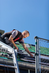 dachdecker legt dachziegel