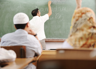 Muslim arabic teacher writing on board