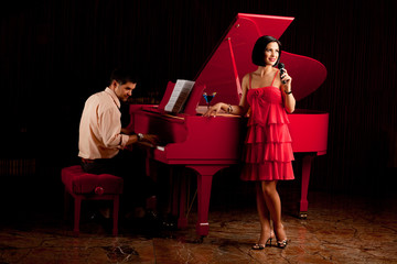 man playing the piano and woman singing