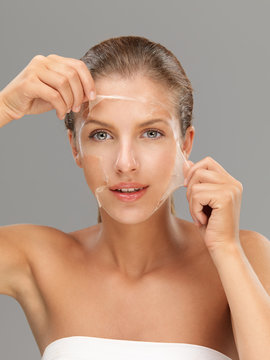 young woman taking off peeling mask