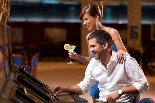 Elegant Couple Playing The Slot Machine