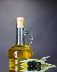 oil and black olives on gray background