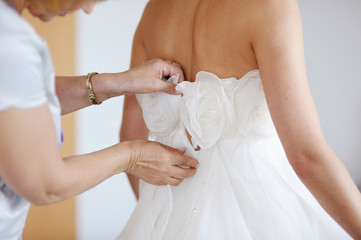 Helping the bride to put her wedding dress on