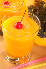 Fresh blended papaya juice with a maraschino cherry
