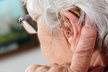 Obraz premium kobieta w wieku z okularami i aparatem słuchowym