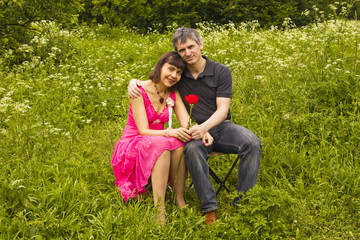 Fototapeta premium Young man presents red rose to young woman