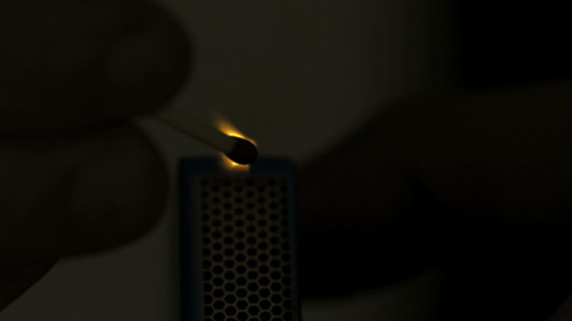 Matchstick lighted in the dark in slow motion