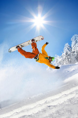 Snowboarder jumping against blue sky