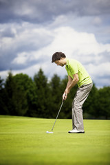 Fototapeta premium Young golf player putting.