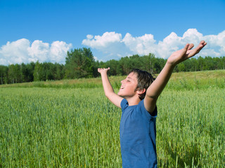 Naklejka na ściany i meble happy boy enjoying summer over wheat field