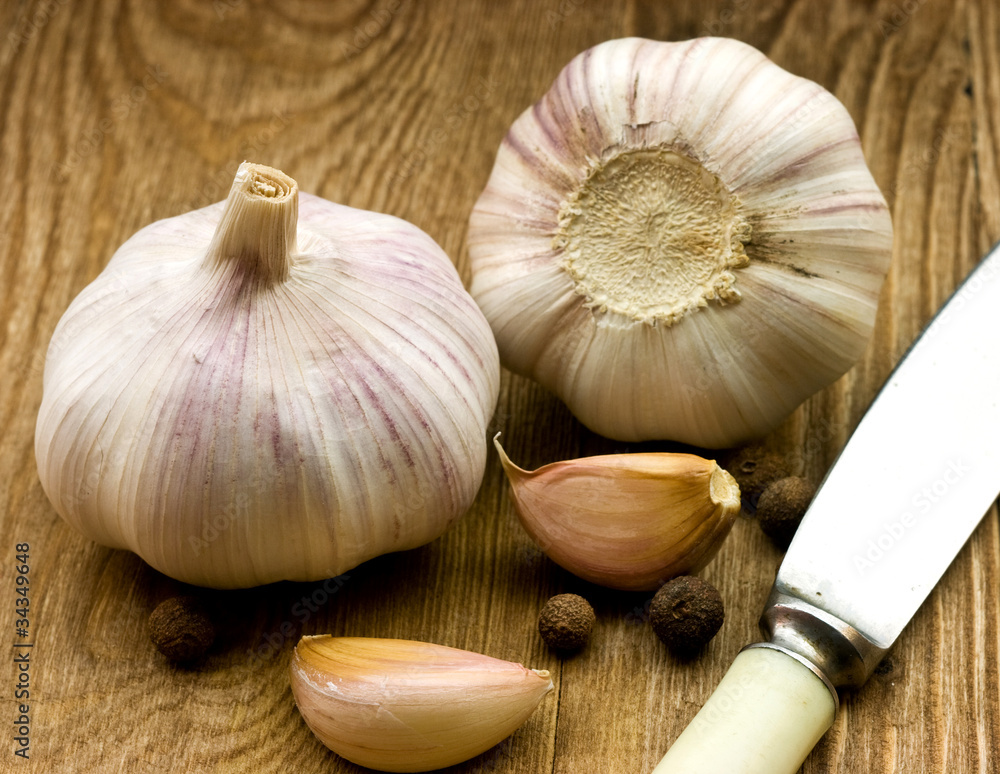 Wall mural garlic on rough chopping board.