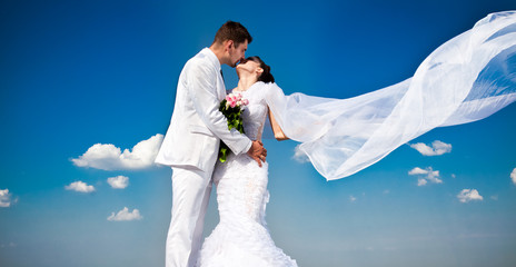 newly married couple.wind lifting long white bridal wedding