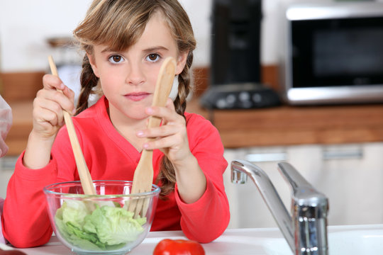 young girl cooking salad
