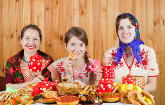 Women eats pancake with tea during  Shrovetide