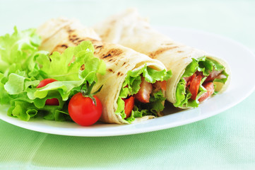 Tortilla rolls with tomatoes,lettuce and ham