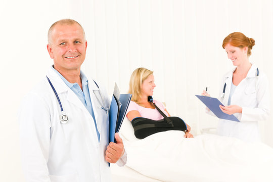 Medical doctors with hospital patient lying bed