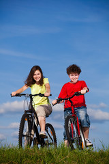 Naklejka premium Girl and boy riding bikes