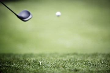 Golf background with driver and ball in air.