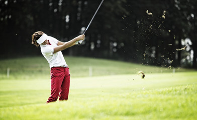 Woman pitching at golf course. - obrazy, fototapety, plakaty