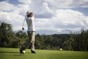 Golfer teeing off.