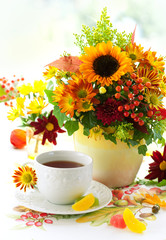 fall still life with cup of tea and autumnal flowers